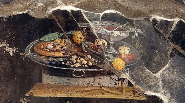 Pompeian still life with round flat bread, fruit and wine.